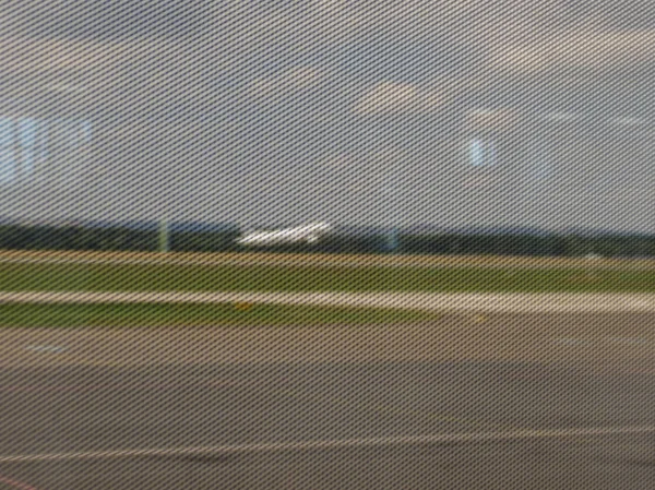 在机场出租车道和跑道上的金属网网围栏与飞机起飞 — 图库照片