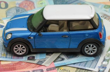 Oxford, İngiltere - Mayıs 2017 yaklaşık: Çin, çocuk oyuncak 2014, yaklaşık olarak Eur Notlar arka plan üzerinde üretilen hafif mavi Mini Cooper araba (2013 sürümü) minyatür gösterimi