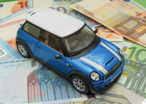 Oxford, İngiltere - Mayıs 2017 yaklaşık: Çin, çocuk oyuncak 2014, yaklaşık olarak Eur Notlar arka plan üzerinde üretilen hafif mavi Mini Cooper araba (2013 sürümü) minyatür gösterimi