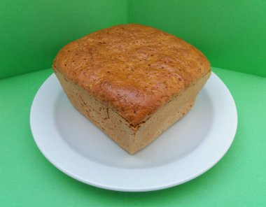 çavdar ekmeği somun yeşil bir arka plan üzerinde beyaz bir tabak içinde