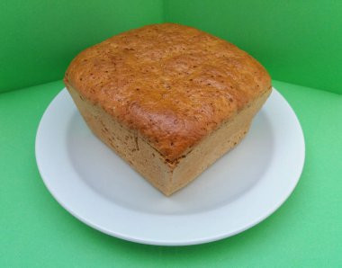 çavdar ekmeği somun yeşil bir arka plan üzerinde beyaz bir tabak içinde