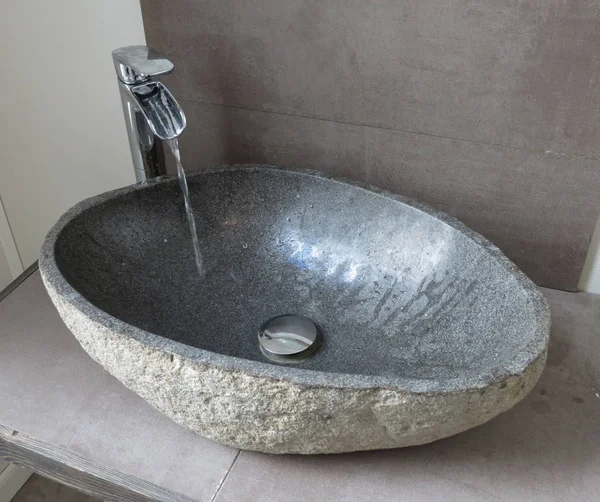 stylish tap and stone sink or trough with water flowing