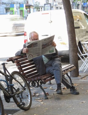 Madrid, İspanya - Ekim 2017 yaklaşık: gazetesi El Pais okuma bir bankta otururken kimliği belirsiz adam