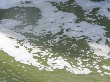 arka plan olarak yararlı köpükle kirli koyu yeşil su yüzeyi