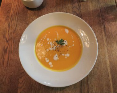 Vejetaryen havuç çorbası masaya bir tabak içinde