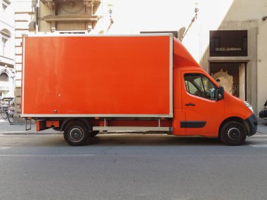 Turuncu minibüs şehir merkezinin bir caddesinde park edilmiş.