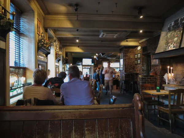 Interiores de un pub irlandés con clientes en Oslo — Foto de Stock