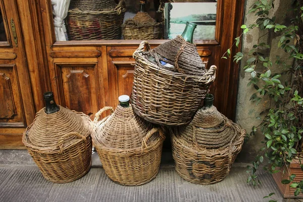 Empty wine bottles in wicker baskets — Stock Photo, Image