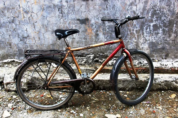 Bicicleta velha na parede de uma casa velha — Fotografia de Stock