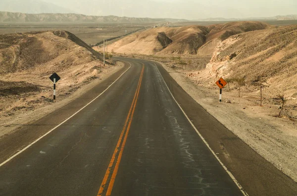 Serpentine carretera de montaña con señales de tráfico, Perú, América del Sur — Foto de Stock