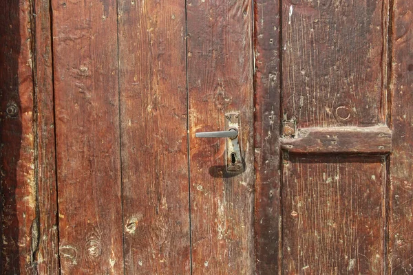 Puerta de madera vieja color rojo oscuro y cerradura de hierro vieja (fragmento ) — Foto de Stock