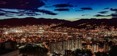 Gün batımından hemen sonra Medellin şehrinin hava görüntüsü tüm bina ışıkları açık.