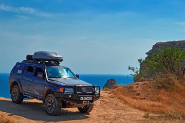 Fiolent, Cumhuriyeti Kırım, Rusya, Kuzey Karadeniz Sahil 10.08.2017. Off-Road aracı dağlar, deniz fonunda standları ve mavi gökyüzü temizleyin.