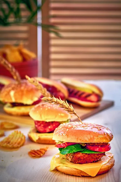 Deliciosas hamburguesas a la brasa con lechuga, tomate, queso y mayonesa sobre una mesa de madera rústica. Gamburguesas caseras, espacio para copiar. Comida rápida. Enfoque selectivo . — Foto de Stock