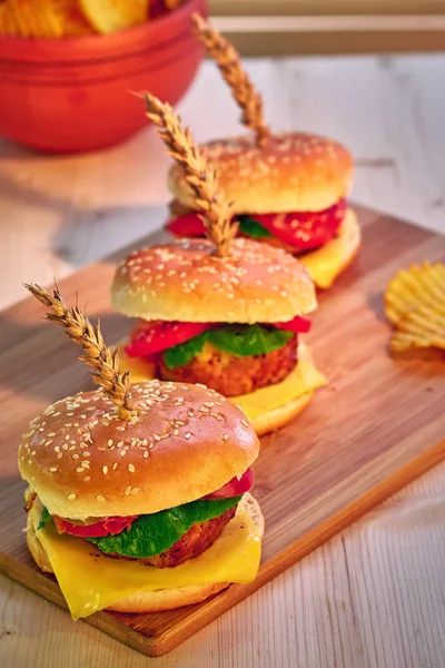 Hamburguesas de ternera a la parrilla con lechuga, tomate, queso y mayonesa sobre tabla rústica de madera. Gamburguesas caseras, espacio para copiar. Comida rápida. Enfoque selectivo . — Foto de Stock