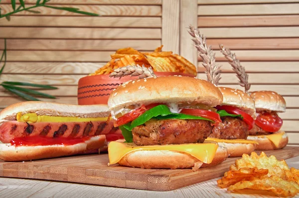 Deliciosas hamburguesas a la brasa con lechuga, tomate, queso y mayonesa sobre tabla rústica de madera. Gamburguesas caseras, espacio para copiar. Comida rápida. Enfoque selectivo . — Foto de Stock