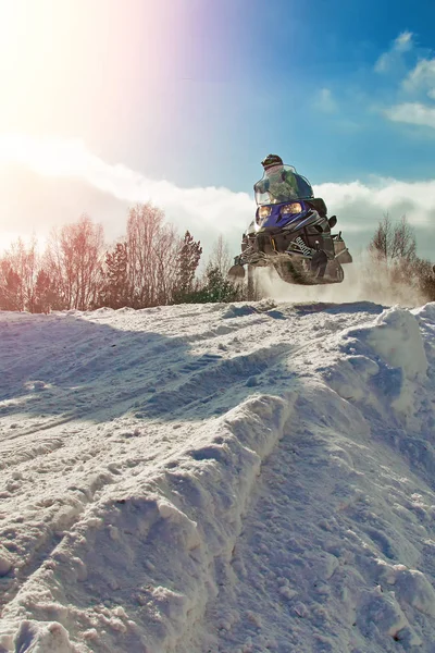 Αθλητικά μπλε snowmobile άλμα. Σαφή ηλιόλουστη χειμωνιάτικη ημέρα. Έννοια γρήγορη κίνηση. Ακραίο άθλημα φόντο για σκοπούς. — Φωτογραφία Αρχείου