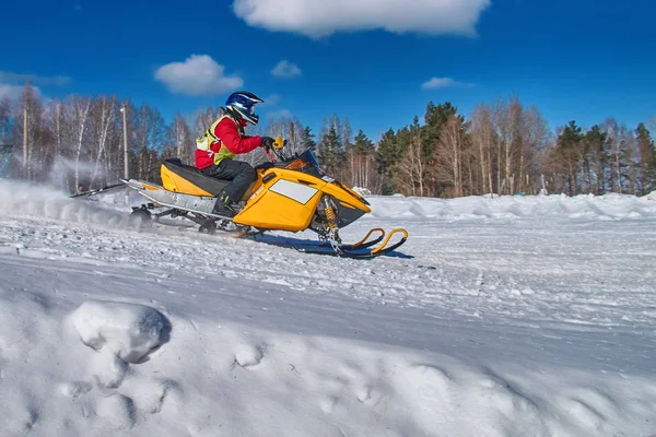 Motoslitta sportiva si precipita ad alta velocità dal pendio. Auto gialla per sport invernali estremi. Concetto movimento rapido . — Foto Stock