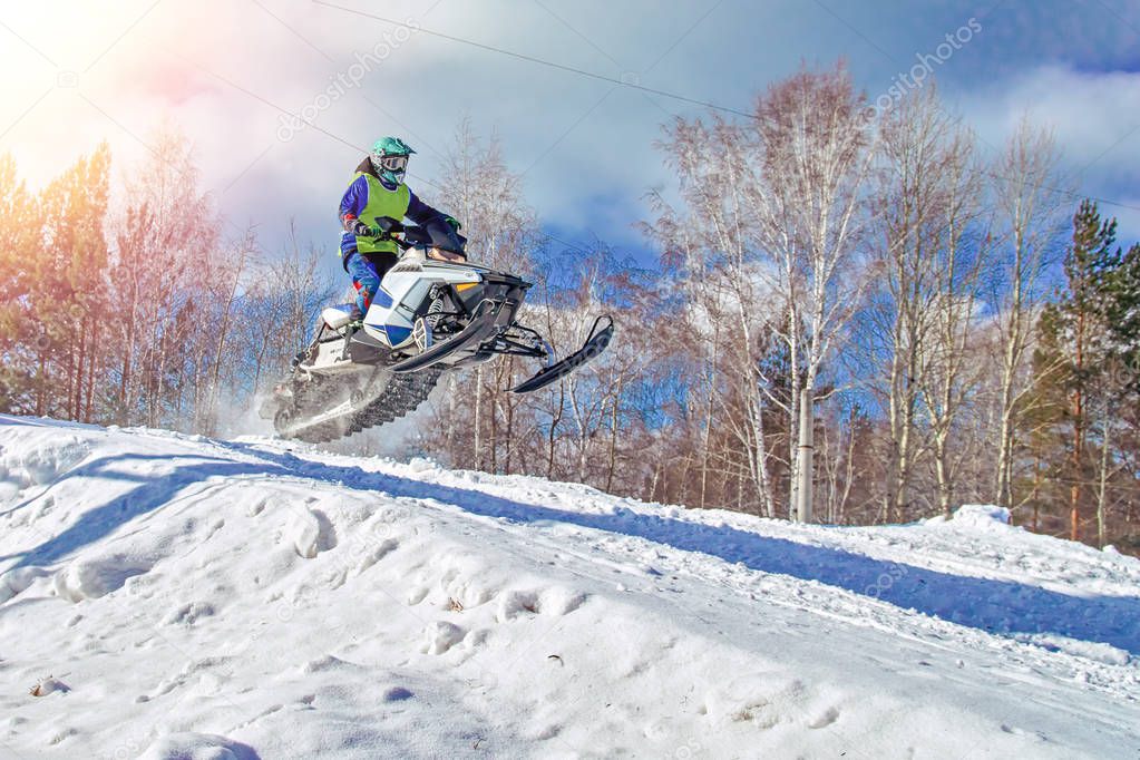 Sport white snowmobile jump. Clear sunny winter day. Extreme sport background for any purposes. Concept quick movement.