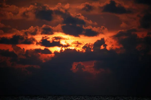 Dramática puesta de sol con nubes a la luz del sol naranja. Puesta de sol en llamas con luz pasando a través de las nubes oscuras. Paisaje . — Foto de Stock