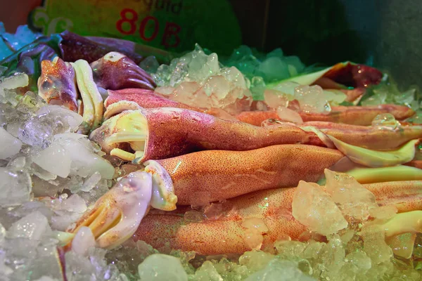 Frisch gefangene Tintenfische liegen auf Eis auf der Ladentheke. Nahaufnahme. Konzept des Straßenhandels mit Meeresfrüchten. — Stockfoto