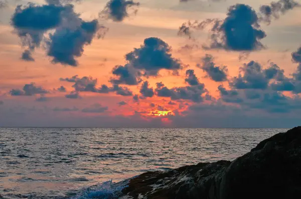 Atardecer de verano en el mar con rocas. Nubes sobre el mar en luz naranja Sol de la noche. Paisaje de soledad . — Foto de Stock