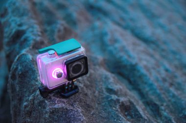 Eylem kamera kayanın üzerinde duruyor. Kamera ışık saçan diyot göstergeler ile su geçirmez koruyucu kutusunda. Turist Gadget'ı. Önden Görünüm.