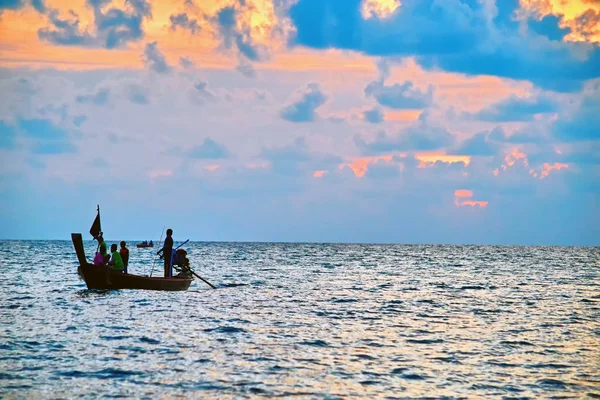 Paisaje marino tropical nocturno con silueta de barco pesquero con gente . — Foto de Stock