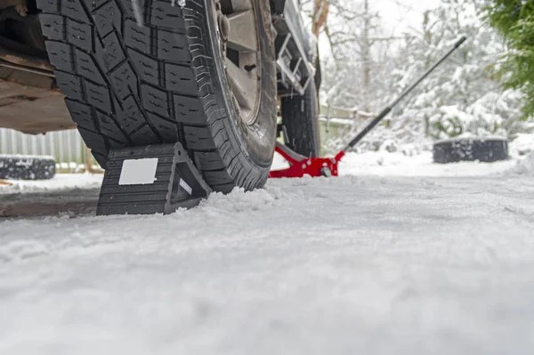 ゴムホイールチョック、反雪の上に車の車輪の下にロールバックを停止します。ホイールチョックアンチスキッド車両ホイール — ストック写真