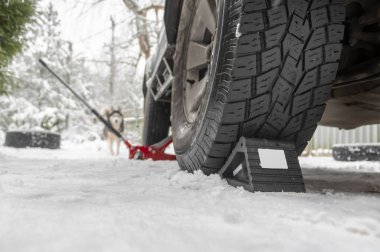 Lastik tekerlek tıkanıklığı. Karda arabanın direksiyonunun altında sıkıştırılmış geri sarma önleyici duruş. Wheel Chocks patinaj önleyici araç tekerleği. Araba Tekerleği Önleyiciler için Tıkaç Durağı Blokları