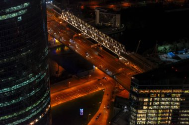 Karanlık arka planda soyut tarzda Panorama Modern Şehir Gecesi. Şehir mimarisi gece manzarası. İş konsepti, gece trafiği. Üst görünüm