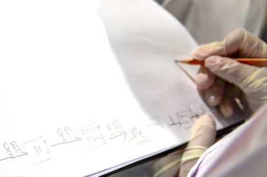 Beyaz kağıda kurşun kalemle çizilmiş malzeme akış haritası, yağsız imalat. Değer akış üretim hattı çiziliyor. seçici odak