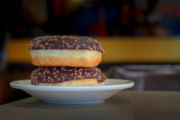 Dos rosquillas de chocolate en el platillo en la cafetería . — Foto de Stock