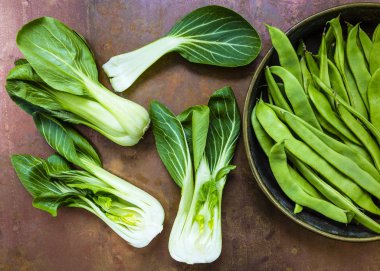 Taze ve çiğ Çin lahanası pak choi ve diğer yeşil bezelye antika arka plan üzerinde. 