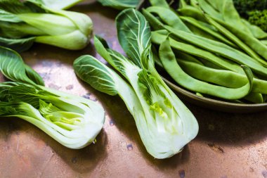 Taze ve çiğ Çin lahanası pak choi ve vintage zemin üzerine yeşil bezelye.