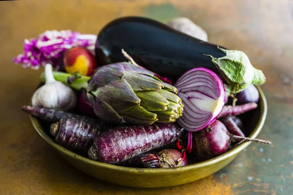 Raw and fresh artichoke and purple vegetables in old bowl. — Stock Photo, Image