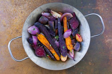 Bir dökme demir tavada otlar ile pişmiş sebze. 