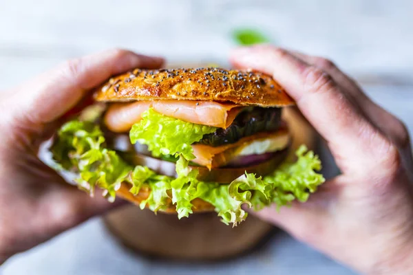 Bagel Mit Lachs Und Frischem Gemüse Den Händen — Stockfoto