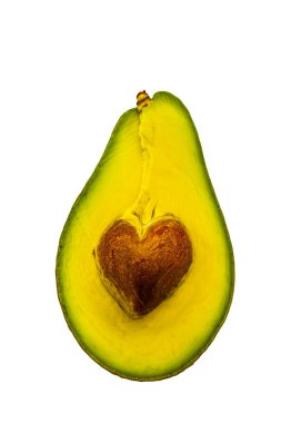 Avokadonun yarısı beyaz arka planda kalp şeklinde tahıl var..