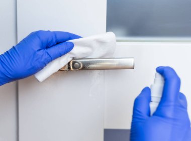 Kapı kolunun yüzeyini dezenfekte ediyorum. Coronavirus önleme, koronavirüs yaymayı durdurmak için hijyen..
