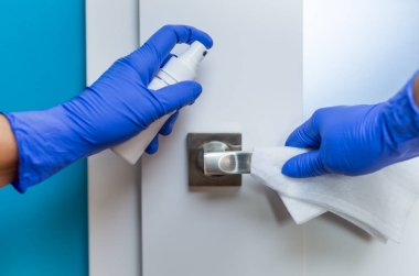 Kapı kolunun yüzeyini dezenfekte ediyorum. Coronavirus önleme, koronavirüs yaymayı durdurmak için hijyen..