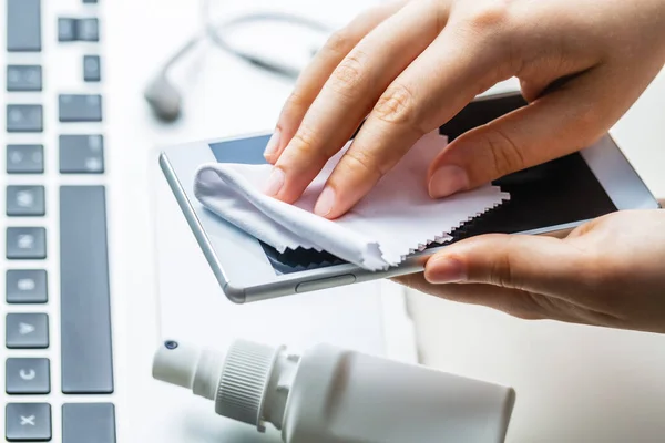 Cep telefonunun yüzeyini temizliyorum. Coronavirus önleme, koronavirüs yaymayı durdurmak için hijyen..