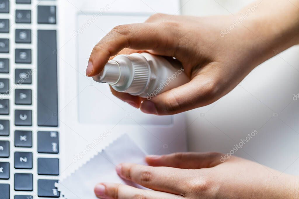 Cleaning the surface of the computer keyboard. Coronavirus prevention, hygiene to stop spreading coronavirus.