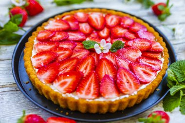 Ahşap arka planda jöleli ve taze çilekli lezzetli sünger keki..