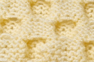 Süveter ya da atkı deseni büyük örgü. Örülmüş forma ve kabartma desenli. Örgü ören örgüler. Yün el örgüsü mü yoksa makine örgüsü mü? Kumaş Arkaplanı.