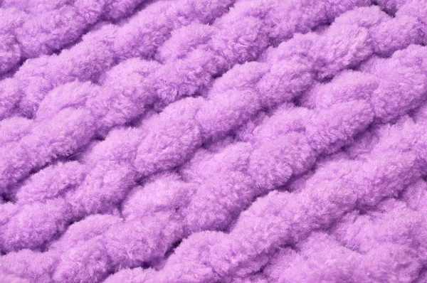 Sweater or scarf texture large knitting. Knitted jersey background with a relief pattern. Braids in knitting. Wool hand-knitted or machine knitting pattern. Fabric Background.