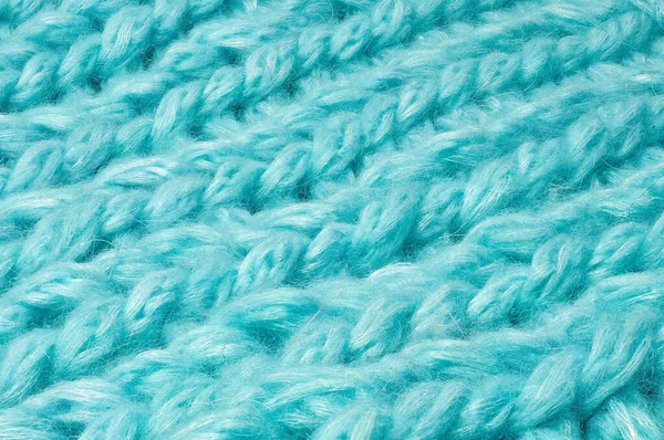 Sweater or scarf texture large knitting. Knitted jersey background with a relief pattern. Braids in knitting. Wool hand-knitted or machine knitting pattern. Fabric Background.