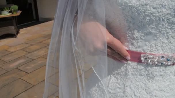 Bruid past de roze riem op een witte trouwjurk — Stockvideo