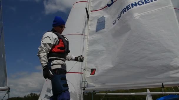 Homme préparant bateau pour commencer pour la régate — Video