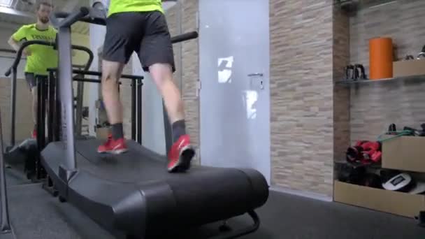 快乐地慢跑 年轻英俊男子在体育馆跑步机上奔跑的镜像 — 图库视频影像